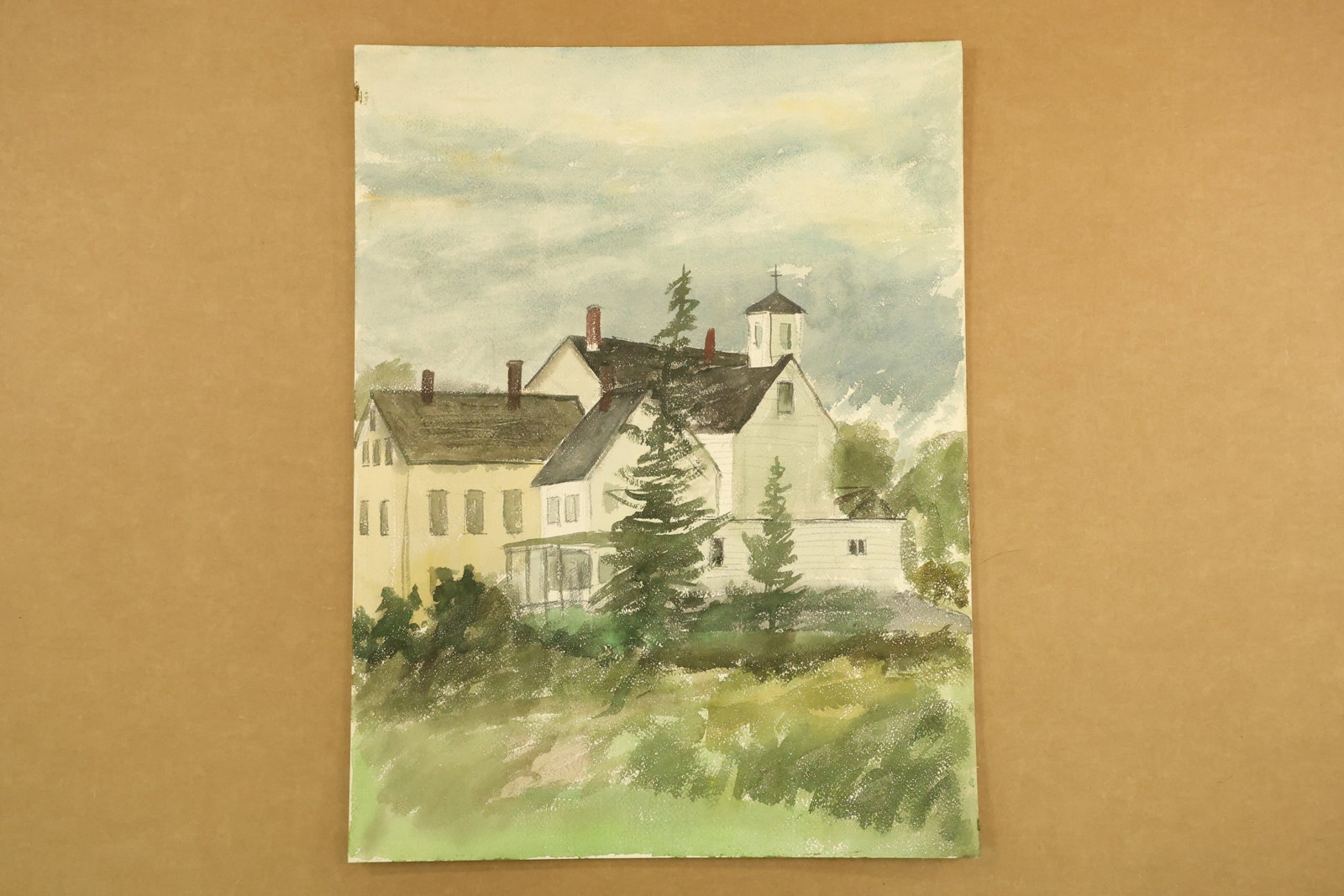 White Building with Cupola Watercolor Attributed to Franklin Shores: Vertical watercolor on paper showing a group of white buildings with dark pitched roofs, red chimneys and a small cupola. Evergreen trees rise in front beneath a softly clouded sky. Unsigned in the su