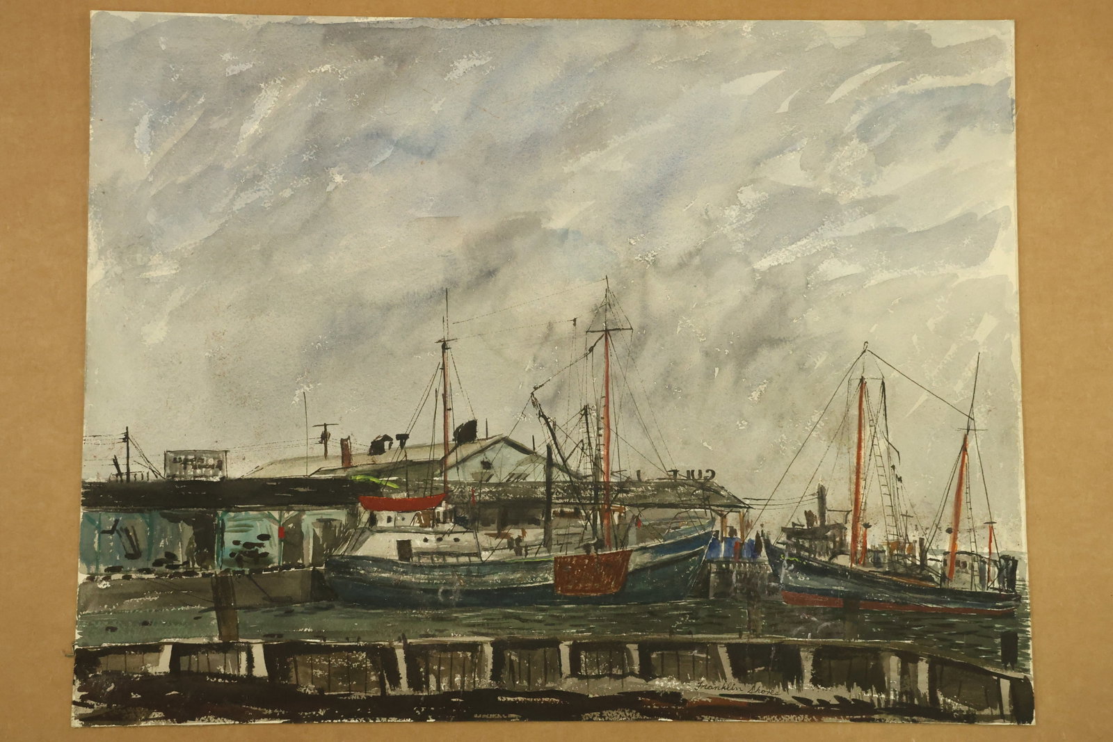 Fishing Boats at Wharf Watercolor Signed Franklin Shores: Watercolor on paper depicting fishing boats beside a working wharf, with tall masts, rigging and low waterfront buildings. Dark hulls and red accents contrast with a broad gray blue clouded sky. Signe