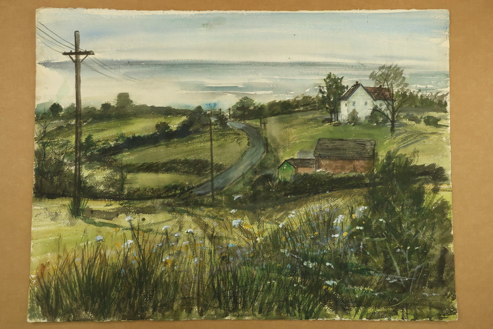 Country Road and Farm Buildings Watercolor Signed Franklin Shores: Watercolor on paper depicting a curving rural road, utility poles, a white house and smaller farm buildings amid green fields. Tall grasses and small blue flowers fill the foreground. A signature read