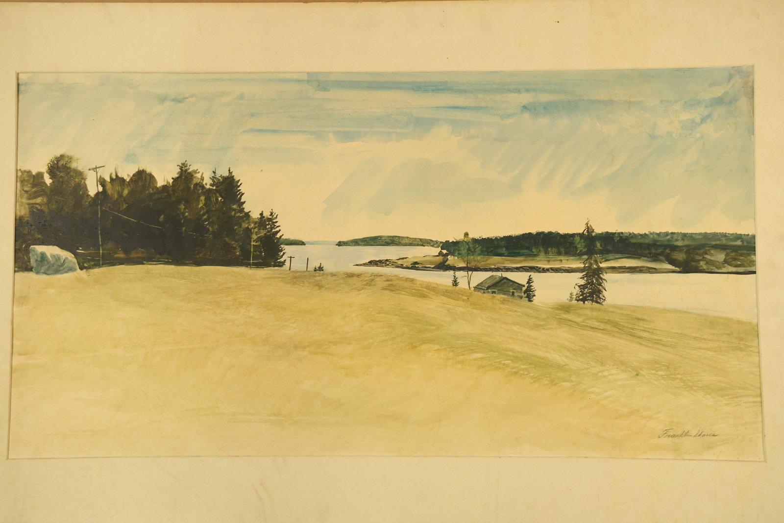 Coastal Field and Distant Buildings Watercolor Signed Franklin Shores: Wide watercolor on paper showing a pale golden field, evergreen trees, small buildings and a distant inlet beneath a lightly clouded blue sky. Signed Franklin Shores at the lower right. Presented with