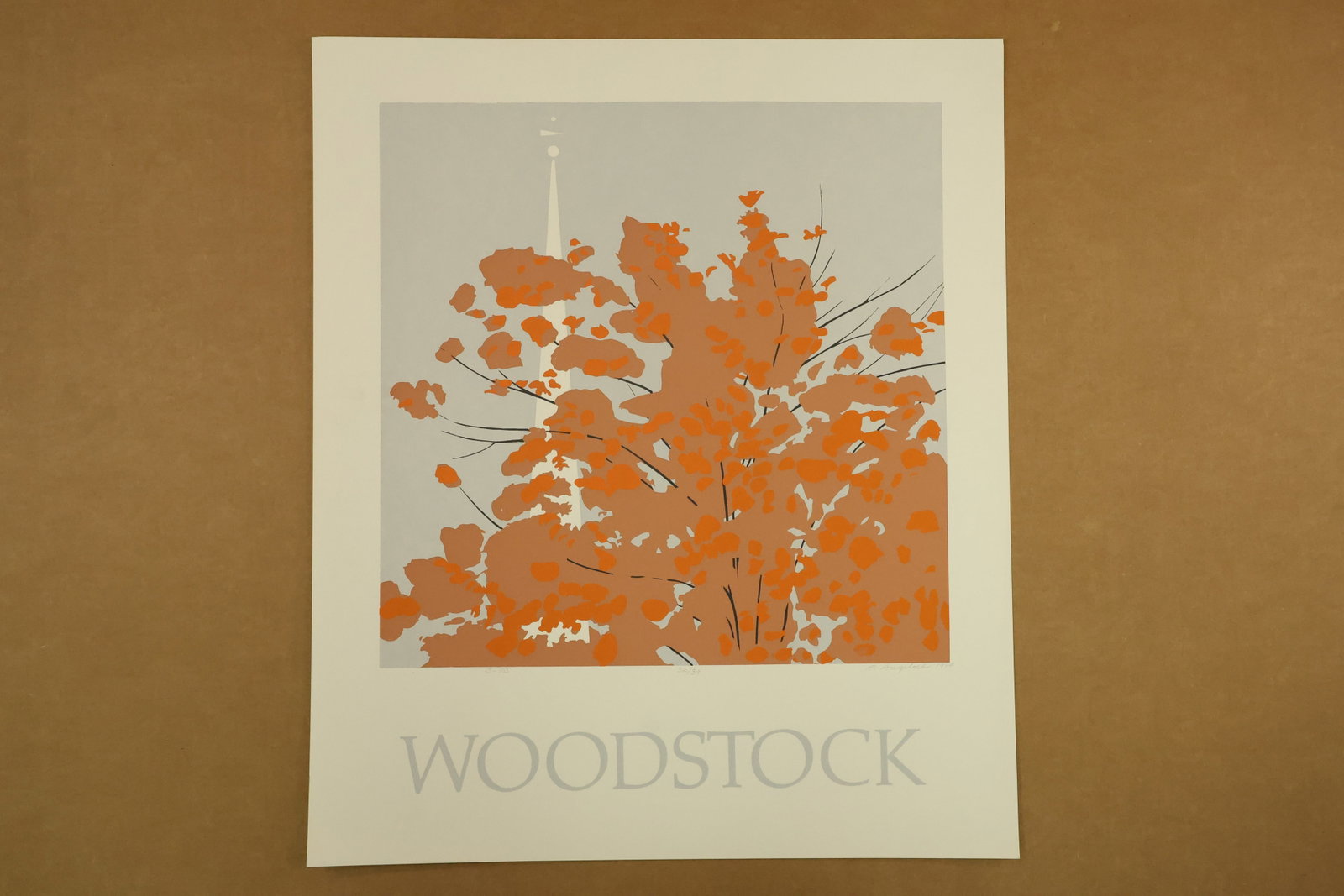 Woodstock Autumn Color Print Signed R Angeloch 1984 Numbered 32/39: Color print on paper depicting orange and brown foliage with fine dark branches and a white steeple against a pale gray sky. WOODSTOCK is printed across the lower margin. Signed R Angeloch, dated 1984