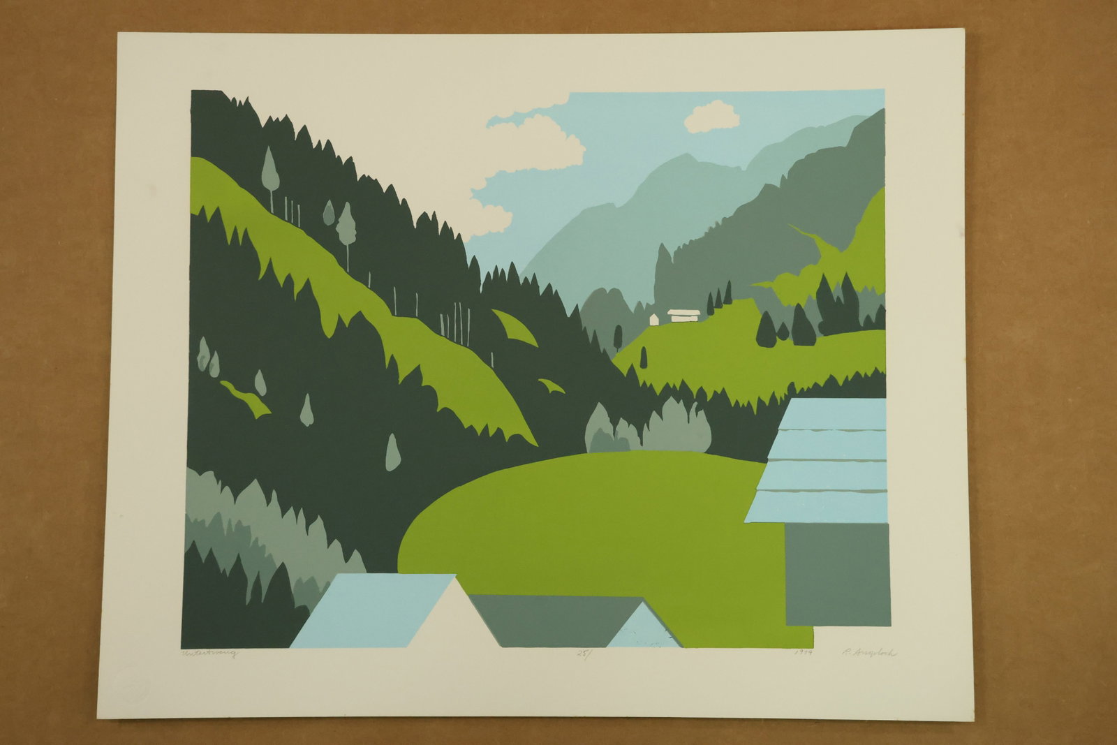 Untertweng Alpine Landscape Print Signed R Angeloch 1979: Color print on paper depicting green hills, dark evergreen silhouettes and pale blue roof shapes below layered mountain ridges. The lower margin is titled Untertweng, signed R Angeloch and dated 1979.