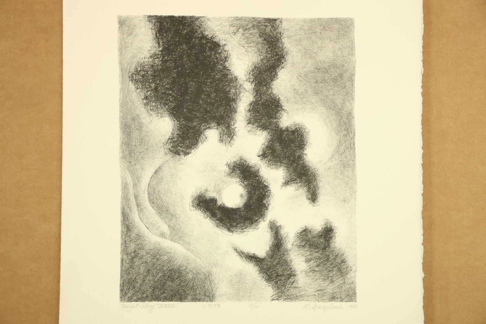 Night Sky XXVII Print Signed R Angeloch 1991 Numbered 4/10: Vertical monochrome print with a pale circular light surrounded by irregular dark clouds and softly graded gray passages. The lower margin is titled Night Sky XXVII, signed R Angeloch, dated 1991 and 
