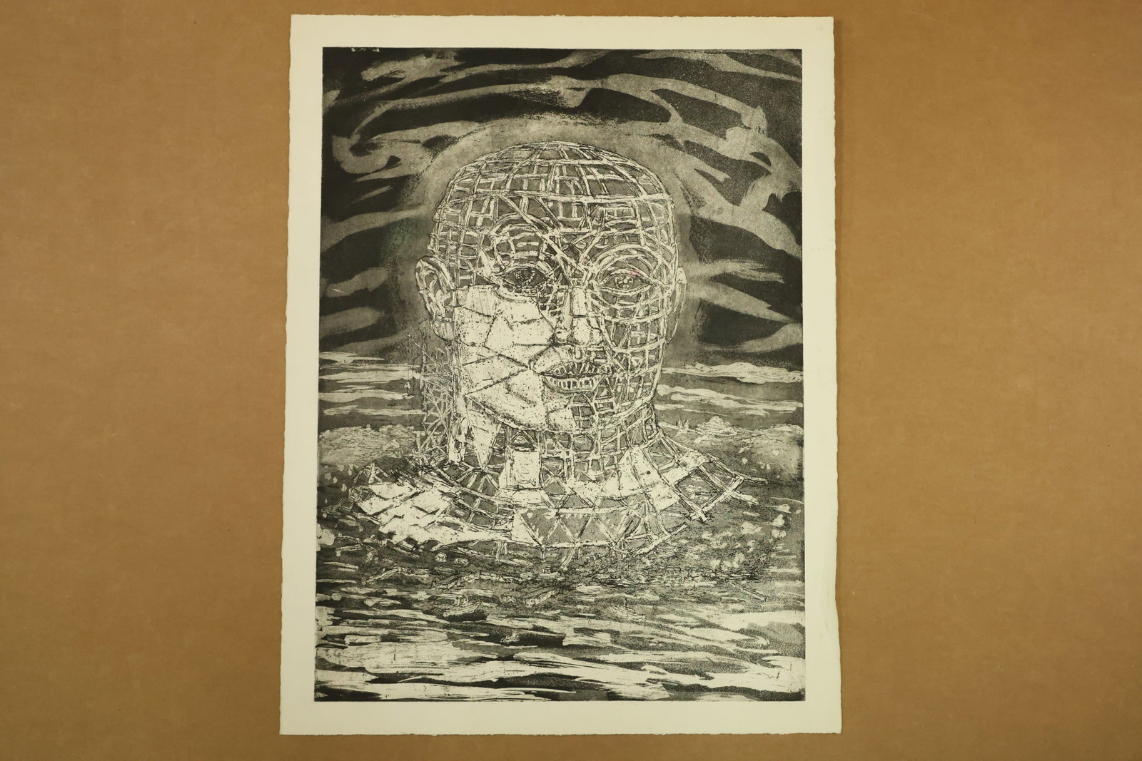 Lattice Head Monochrome Print Attributed to Peter Passuntino: Monochrome print on paper depicting a large frontal head enclosed by an irregular grid or cage like network. Fine facial contours overlap the lattice above a dark rippling ground. Unsigned in the supp