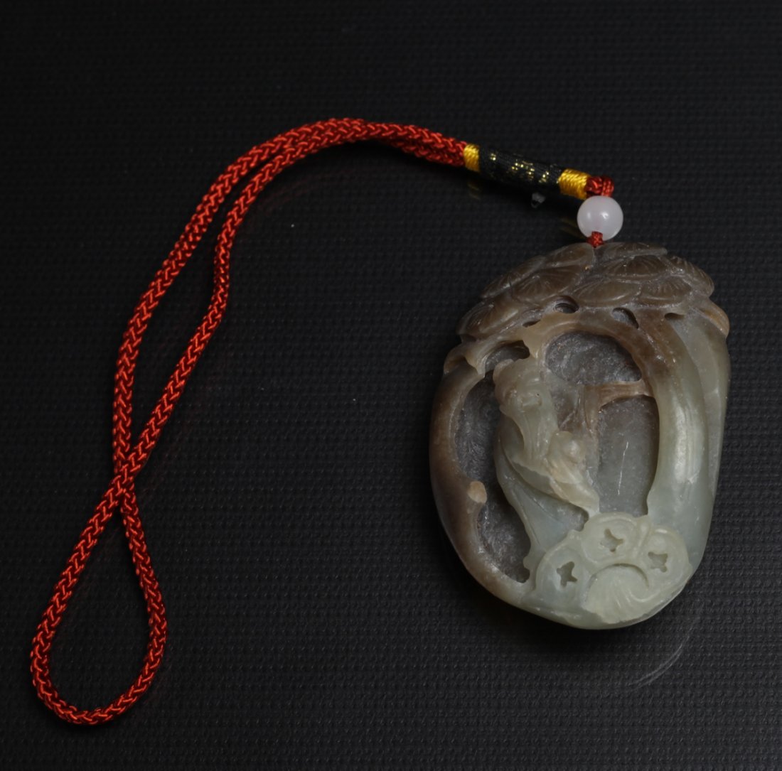 Chinese Carved Hardstone Pendant: Carved to depict and elder beneath a tree. Attached to cord, pendant measures 2.375" H x 1.625" W.