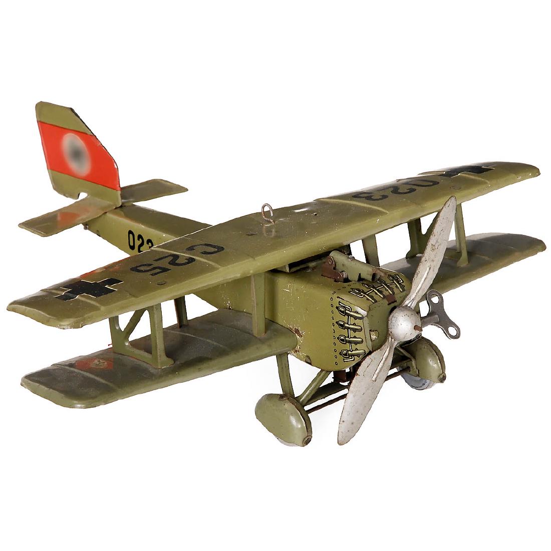 Distler Military Biplane, c. 1935: Distler Military Biplane, c. 1935 Johann Distler, Nuremberg, Germany. Pre-war model, lithographed tin, spring-drive for propeller and wheels (working), 2 swastikas on the back tail fin, machine gun p