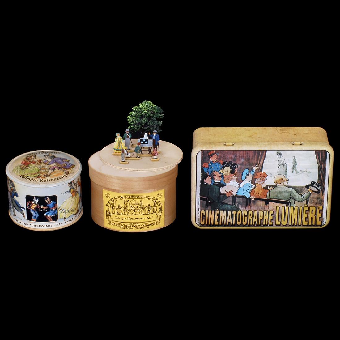 3 Boxes with Photo and Movie Motifs: 3 Boxes with Photo and Movie Motifs 1) Tin figures "Der Guckkastenmann 1855", chipped wood, height of figures only 3 1/6 in., labeled: "Aus dem Berliner Zinnfigurenkabinett Werner Scholtz". - 2) Small