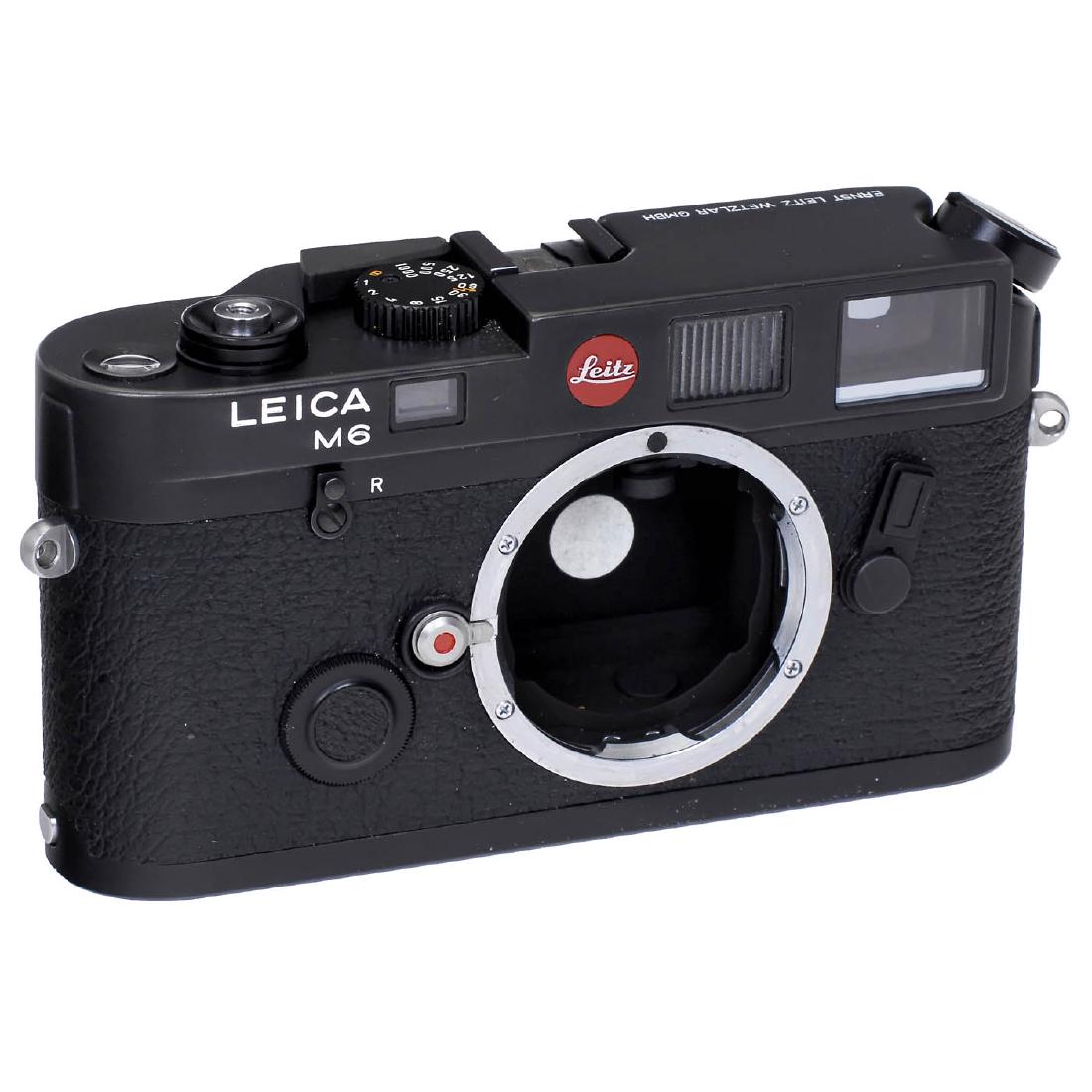 Leica M6 Body, 1986: Leica M6 Body, 1986 Leitz, Wetzlar. No. 1711153, type 10404, black, base plate with user marks. With leather case (like new), body cap and instruction manual. Leica M6 Gehäuse, 1986 Leitz, Wetzlar. N
