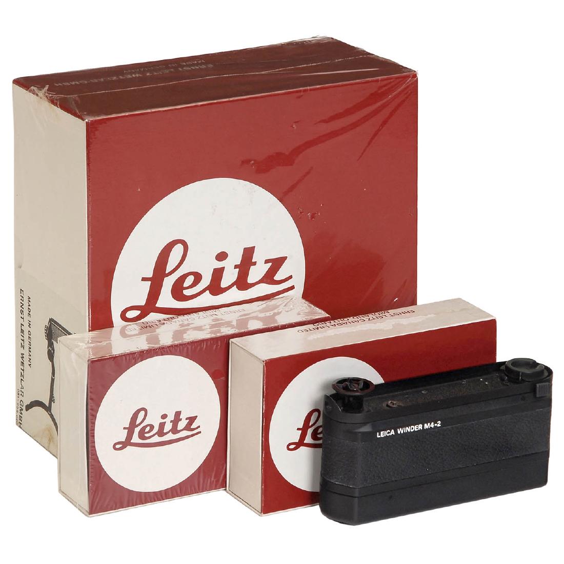 2 Leica Winders M (M4-2): 2 Leica Winders M (M4-2) Leitz, Wetzlar. 1) Leica Winder M (14403), original box. - And: 2) Leica Winder M4-2 (14214), original box. - In addition: Universal grip (14188), original box. 2 Leica Winder