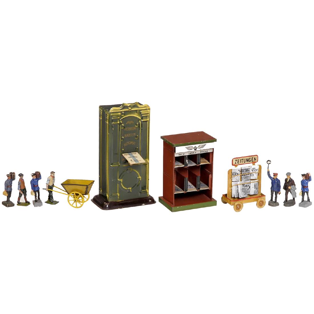 Group of Railway Accessories, c. 1920 onwards: Group of Railway Accessories, c. 1920 onwards 1) Gebrüder Bing. "Perron Karten Automat", with original cards, height 6 ¾ in. - 2) Britain. Man with wheelbarrow, cast-metal and tin. - 3) Kibri. News 