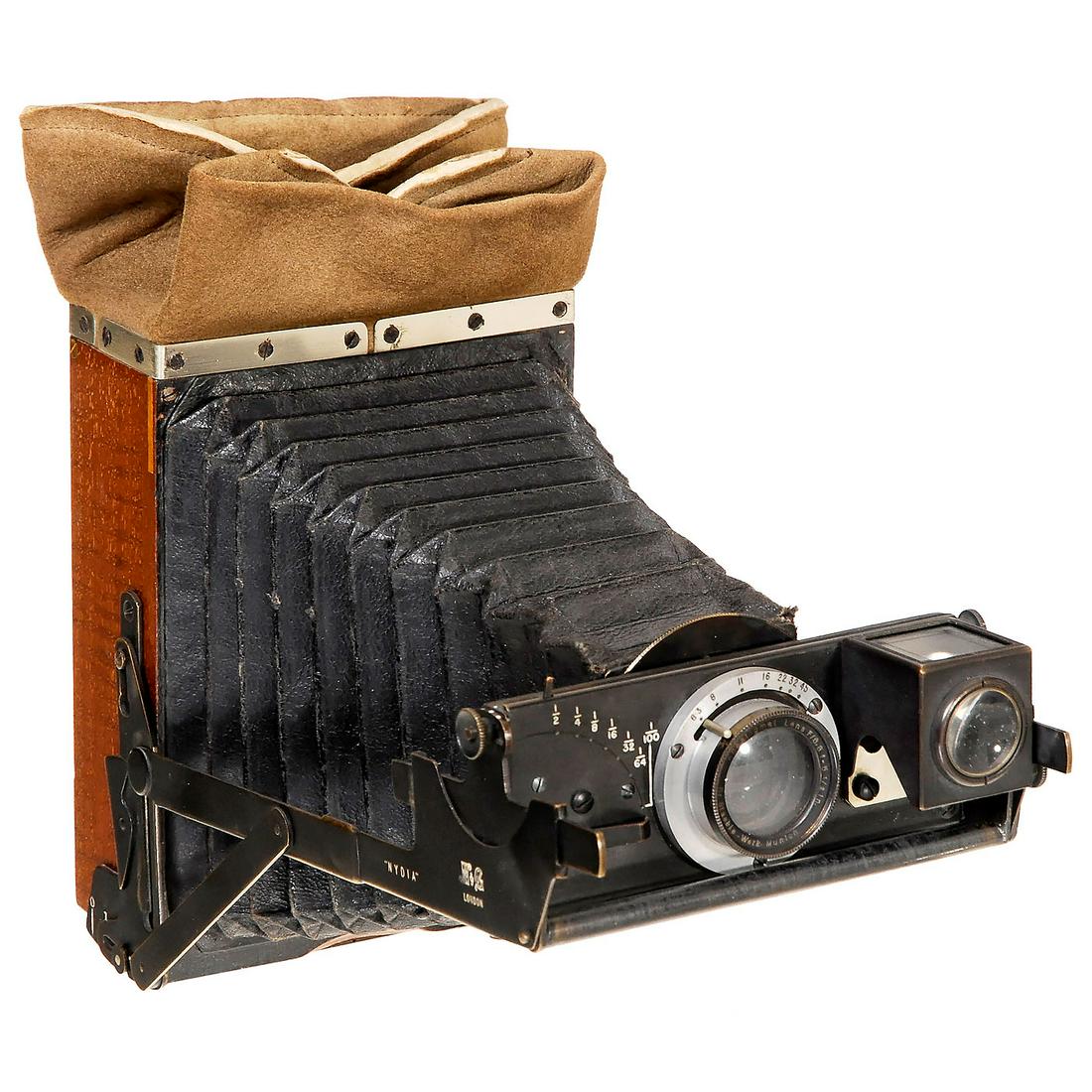 Nydia (¼ Plate), c. 1899: Nydia (¼ Plate), c. 1899 Newmann & Guardia Ltd., London. Rare and unusual folding plate camera, tropical wood with brass fittings, changing sack, plate size 10,8 x 8,1 cm, body no. 1423 inside,