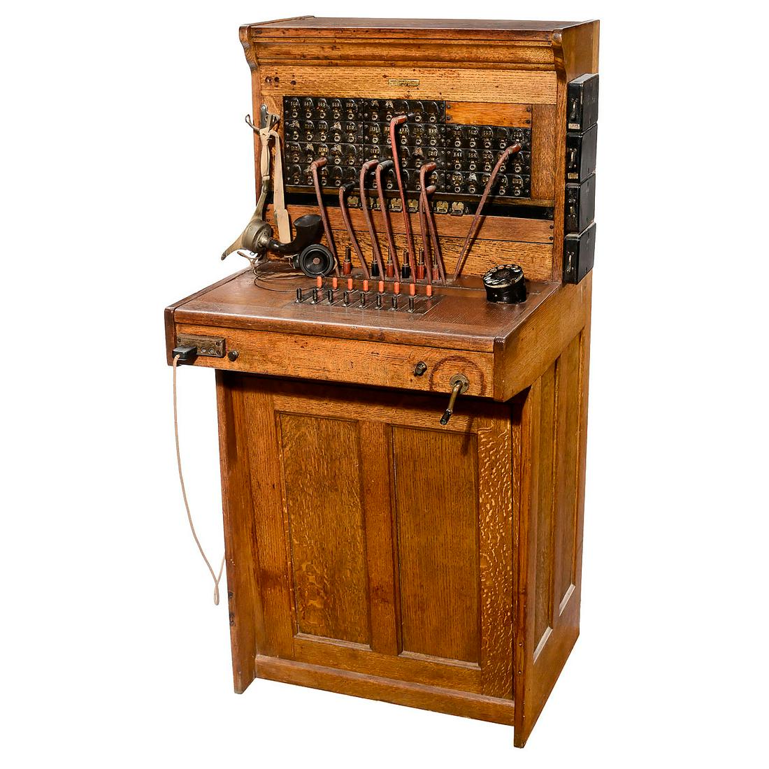 Western Electric Co. Telephone Operators Switchboard,: Western Electric Co. Telephone Operators Switchboard, c. 1905 USA, upright floor model, oak case, size 27 x 27 ½ x 55 ½ in., with rotary dial, crank, switches, knobs, cords and Stromberg Carlson he