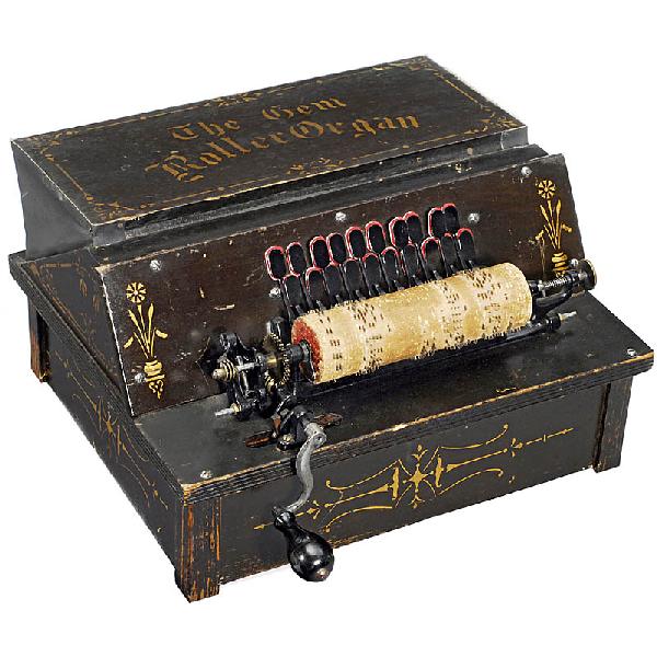 "The Gem Roller Organ", 1887: "The Gem Roller Organ", 1887 Hand-cranked reed organ, manufactured by: "Autophon Company", gold ornamented wooden case, with metal-pin-studded wooden cylinder which plays each tune in 3 spiral turns.