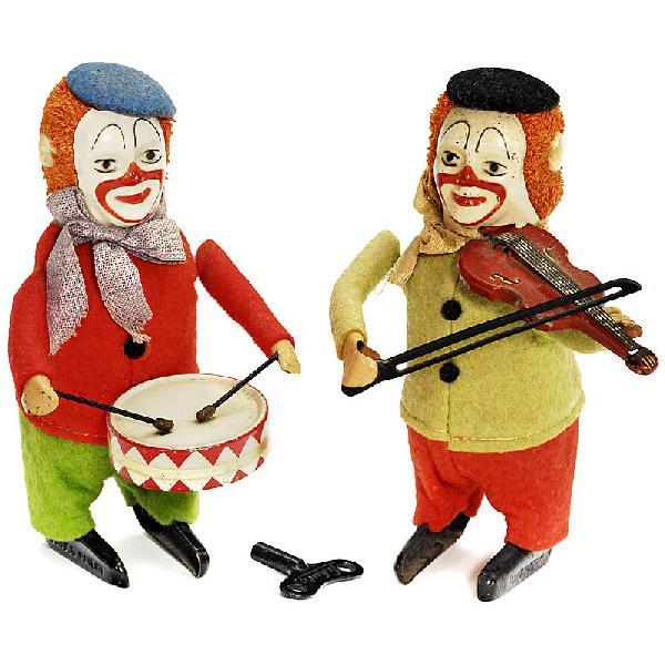 2 Schuco Dance Figures: 2 Schuco Dance Figures 1) Clown as violinist (no. 986/2). - And: 2) Clown as drummer (no. 986/1). - Each with tin case and colorful felt clothes, with spring motors (working), with 1 key. Deutsche Bes