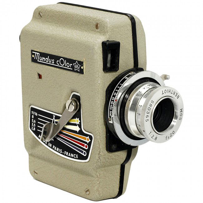 Mundus Color 65, 1974: Mundus Color 65, 1974 Mundus, France. Subminiature camera 8 x 14 mm (double 8), styled like a movie camera, interchangeable lens "Berthiot 2,8/25", grey body, with lens cap. Mundus Color 65, 1974 Mund