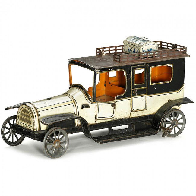 Large Limousine by "Günthermann", 1914: Large Limousine by "Günthermann", 1914 Germany, lithographed tin, clockwork mechanism (working), without driver figure, rubber tires and side lanterns, length 13 in., with tin suitcase. Günthermann: