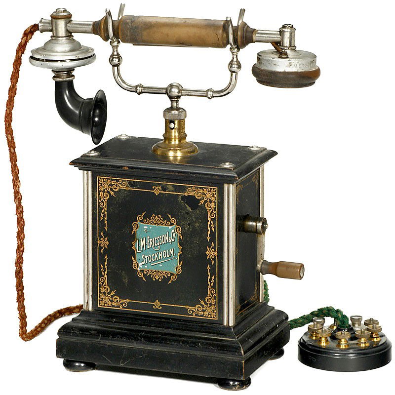 Desk Telephone "L.M. Ericsson", c. 1902: Desk Telephone "L.M. Ericsson", c. 1902 Decorated tin case, wooden base, double bell, magnet generator. Tischtelephon "L.M. Ericsson", ab 1902 Verziertes Blechgehäuse, Holzsockel, Doppelwecker, 3-lam