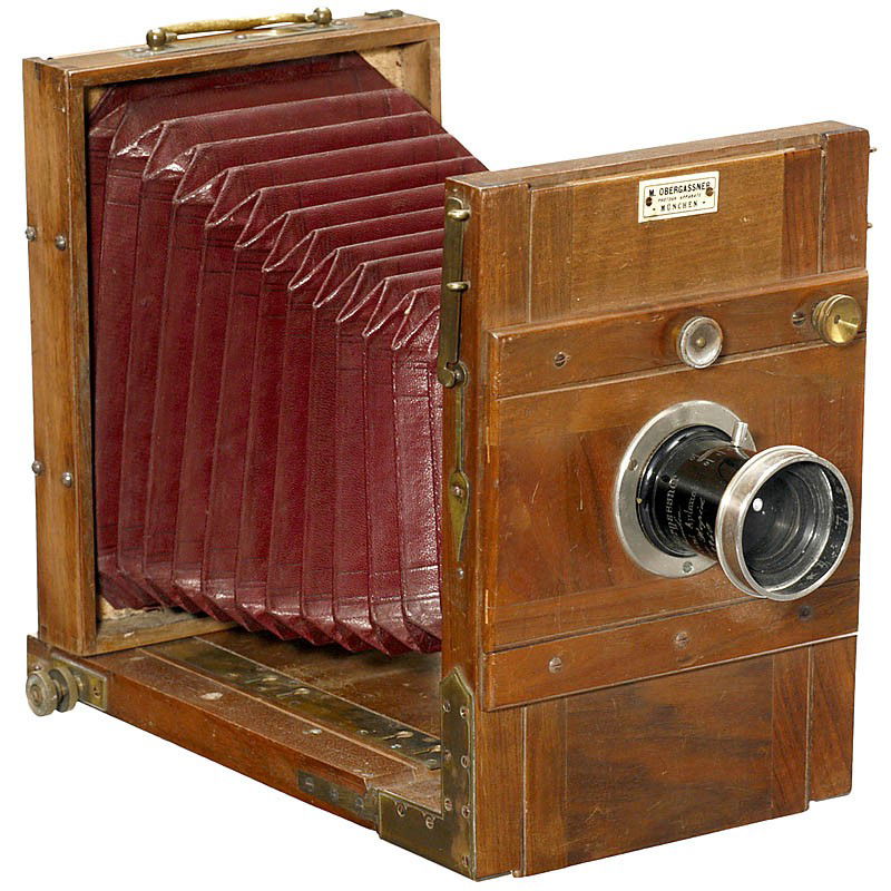 Tailboard Camera by M. Obergassner in Munich, c. 1: Tailboard Camera by M. Obergassner in Munich, c. 1889 Sales: M. Obergassner KG, Munich, Kaufingerstr. 33, founded in 1889. Size 13 x 18 cm, brass fittings, dark red conical bellows, lens: "M. Obergass