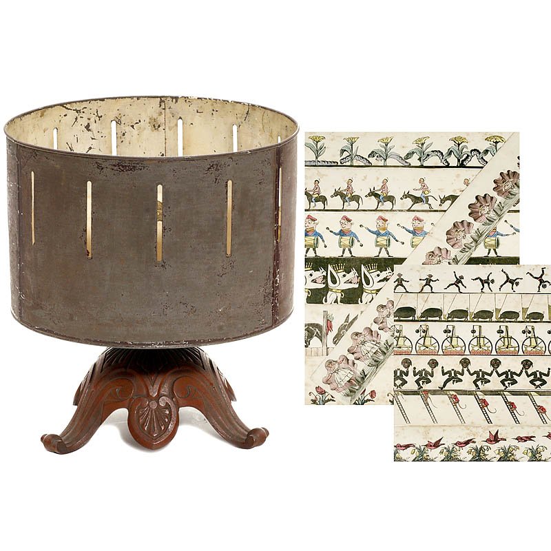 Zootrope, c. 1900: Zootrope, c. 1900 Tin drum and tin stand, drum size Ø 11 2/5 in., height: 13 in. With 13 paper strips. Zootrope, um 1900 Wundertrommel auf Metallfuß, mit Blechtrommel Ø 29 cm, Höhe: 33 cm. Mit 13 