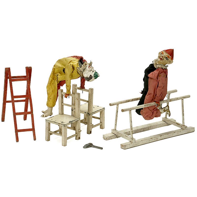 French Clown Acrobat Automaton Toy by Migault, c. 1930: French Clown Acrobat Automaton Toy by Migault, c. 1930 With articulated metal head and arms, clockwork mechanism in the torso causing acrobat to perform somersaults on a pair of white-painted chairs, 
