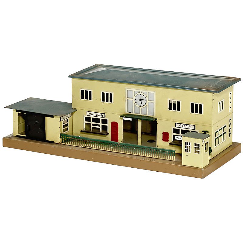 "Märklin" Station, No. 2002B, Gauge 0: Märklin Station, No. 2002B, Gauge 0 Painted tin, with goods shed and platform barrier, no flagpole, size 19 x 7 2/3 x 6 ¾ in. Bahnhof "Märklin" Nr. 2002B Spur 0 Lackiertes Blech, mit Güterschuppen