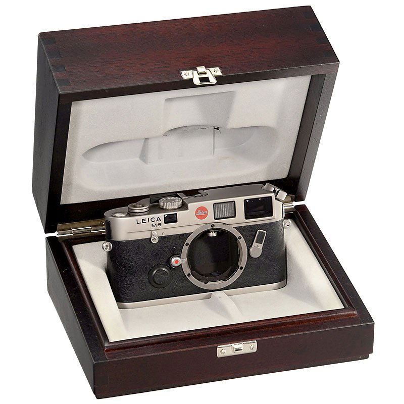 Leica M6 Titanium, 1995: Leica M6 Titanium, 1995 Leica, Solms. No. 2168775, titanium-plated, leather covering with "emu" pattern, like new. With inner and outer box, and additional wooden presentation case. – Add-on: M6 eve