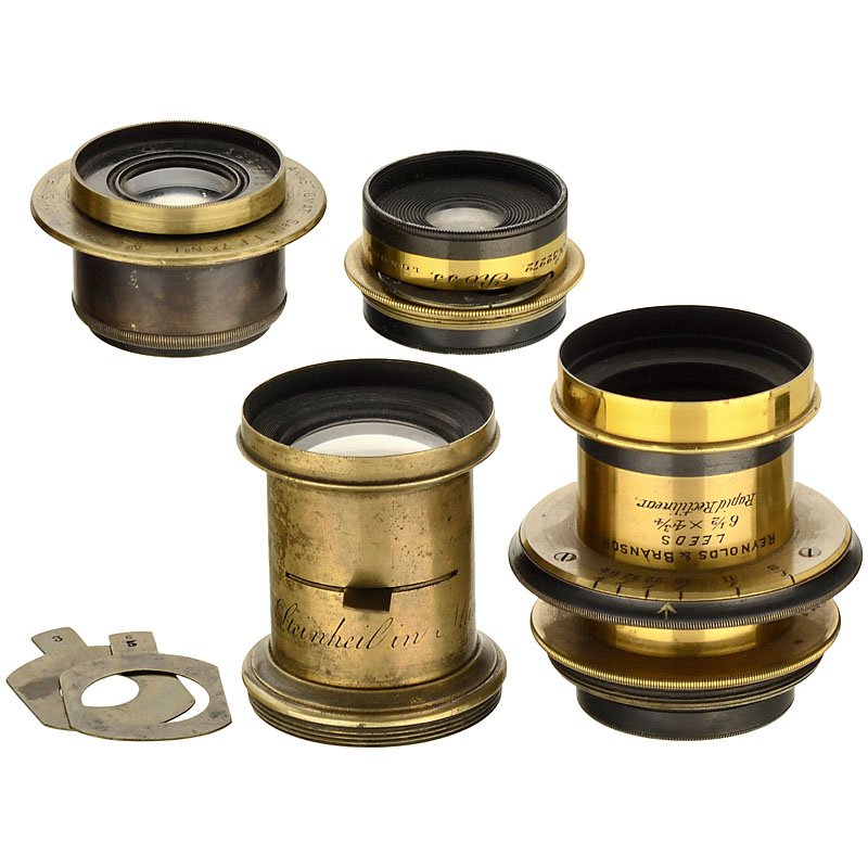 4 Small Brass-Bound Lenses: 4 Small Brass-Bound Lenses 1) Reynolds & Brandson. Rapid Rectilinear 6 ½ x 4 ¾, iris stop, height 2 3/4 in., Ø 2 in. (3+/3). – 2) E. Suter, Basel. Anastigmat Serie I F. 7,2 No. 1, iris stop, heig