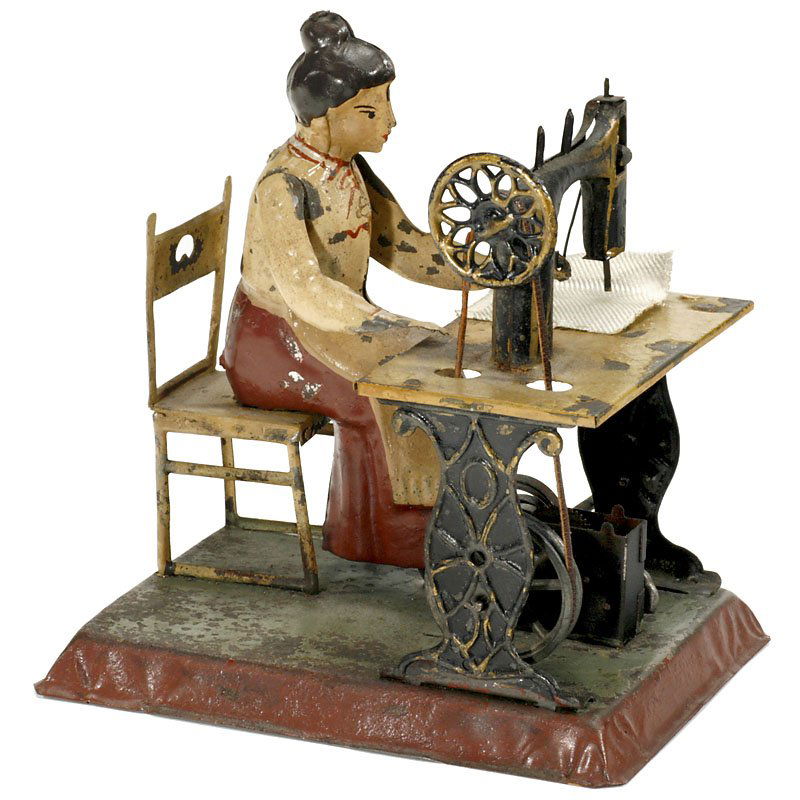 Woman on Sewing Machine, c. 1905: Woman on Sewing Machine, c. 1905 Made by Günthermann, Nuremberg. Good original condition, hand-painted tin, clockwork working. – A very fine item for collectors of toys as well as sewing machines!