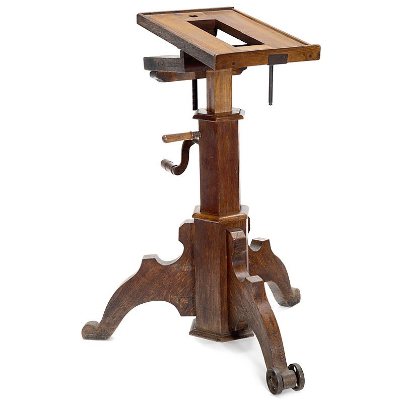Studio Tripod, c. 1880: Studio Tripod, c. 1880 Polished wood, inclining baseboard, approx. 11 ¾ x 20 in., base height: 35 ½ in., crank mechanism. For early wet-plate camera! Studiostativ, um 1880 Edelholz, neigbares Grun
