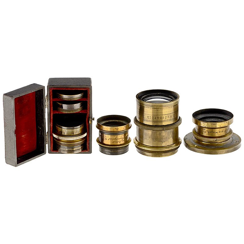 4 Brass Lenses, c. 1900: 4 Brass Lenses, c. 1900 1) Rodenstock, Munich. Rapid-Aplanoscop 7,5 18 x 24, no. 62642, iris stop, height: 2 ¾ in, Ø 2 in. (3–2/2) – 2) Ross, London. 5 in. Double Anastigmat 7,7, height: 1 ½ in