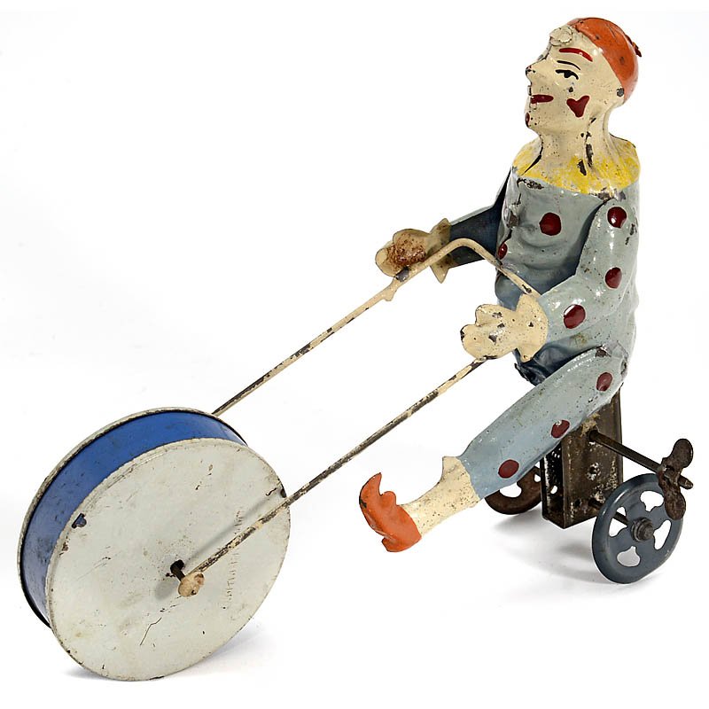 Günthermann Tin Toy Figure "Clown on Tricycle", c. 1910: Günthermann Tin Toy Figure "Clown on Tricycle", c. 1910 Clockwork-driven circus clown, hand-painted tin, large front wheel with simple musical movement, missing right leg, length 6 ½ in. Güntherma