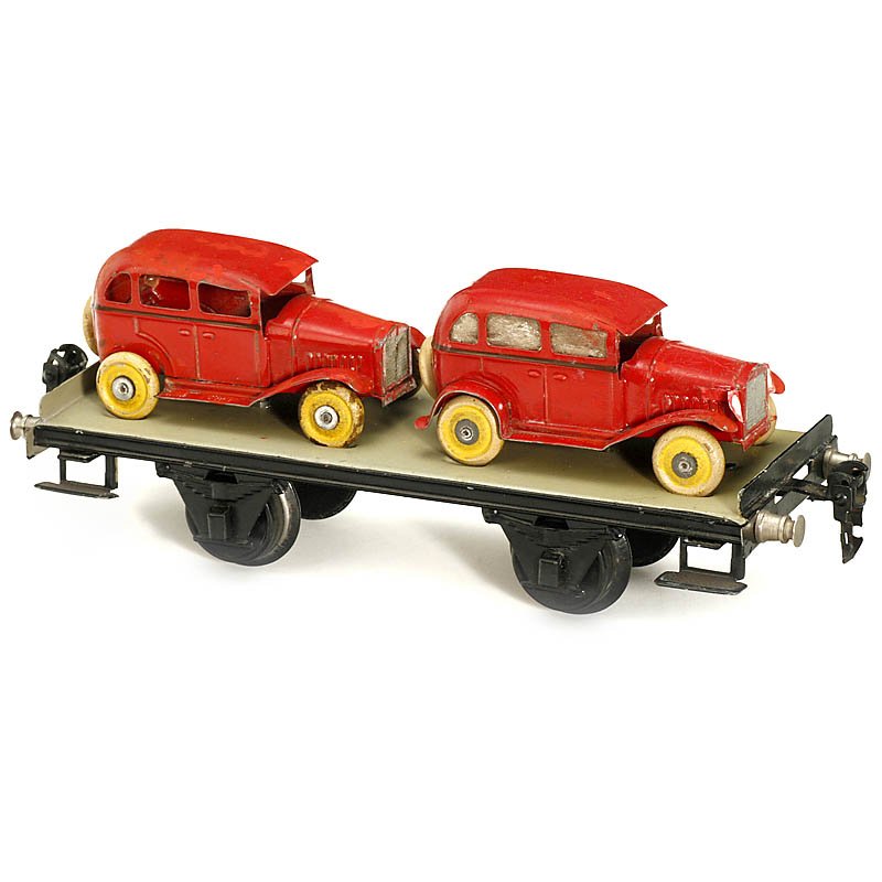 Märklin Stage Wagon with 2 Cars No. 1766/1, Gauge I, c.: Märklin Stage Wagon with 2 Cars No. 1766/1, Gauge I, c. 1933 Hand-japanned tin, with 2 vintage cars (finish partly renewed), length 9 ½ in. Plattformwagen mit 2 Autos "Märklin" Nr. 1766/1 Spur 1, u