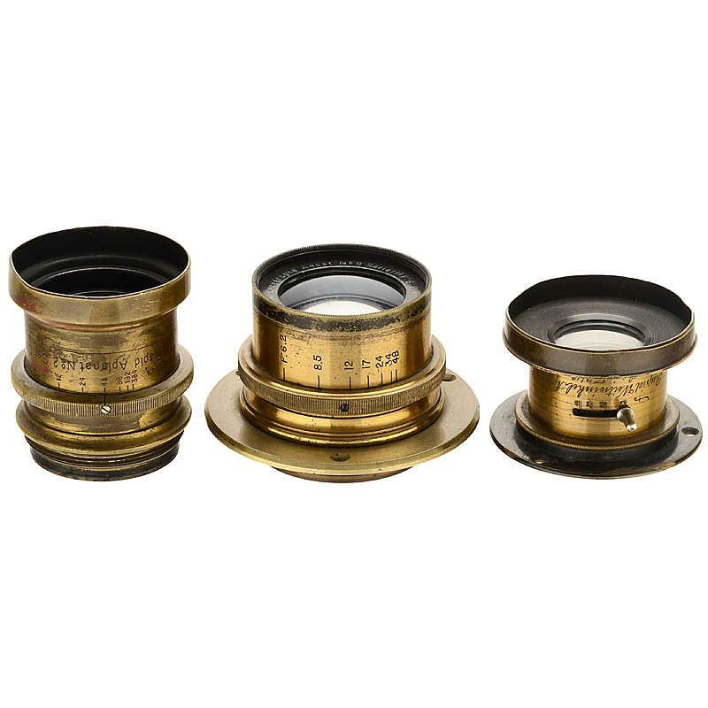 3 Brass Lenses, c. 1890: 3 Brass Lenses, c. 1890 1) Lacour Berthiot, Paris. Eurygraphe Anast. No. 8 Serie 11b 6,2/180 mm, iris stop, height 45 mm, with connecting ring. (3/3–4) – 2) R.O.J.A. vorm. Emil Busch. Rapid Aplana