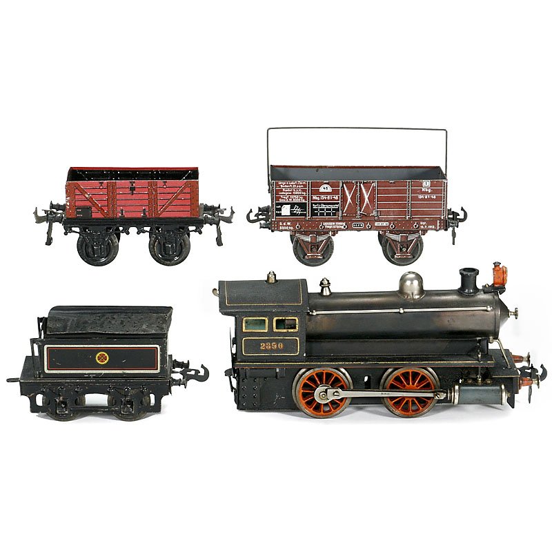 Live Steam Gauge I Locomotive by Carette, c. 1912: Live Steam Gauge I Locomotive by Carette, c. 1912 No. 2350, 2 fixed cylinders, lithographed tin, complete with burner, length 17 ¾ in. – In addition: 2 freight wagons (1 x Carette). Spiritus-Dampfl