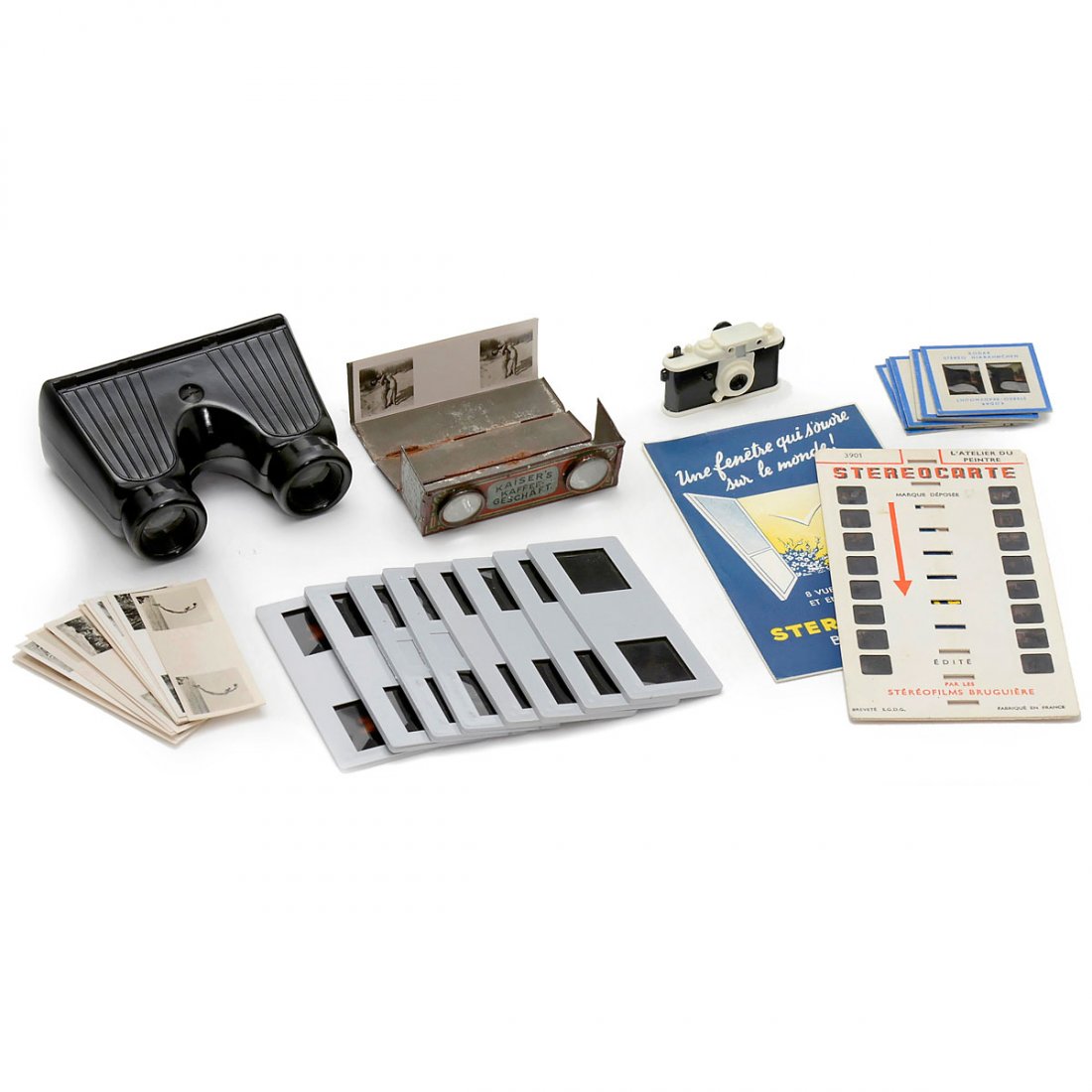 2 Stereo Viewers with Nude Photos: 2 Stereo Viewers with Nude Photos 1) Pocket viewer "Kaiser's Kaffee Geschäft", lithographed tin, foldable, with 12 nude photos 8,5 x 3 cm. – 2) Bakelite viewer with 8 stereo slides of 10 x 4 cm. ��