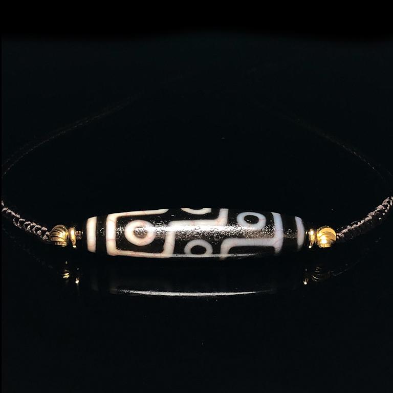 AN AGATE NINE-EYED DZI PENDANT (1 of 9)