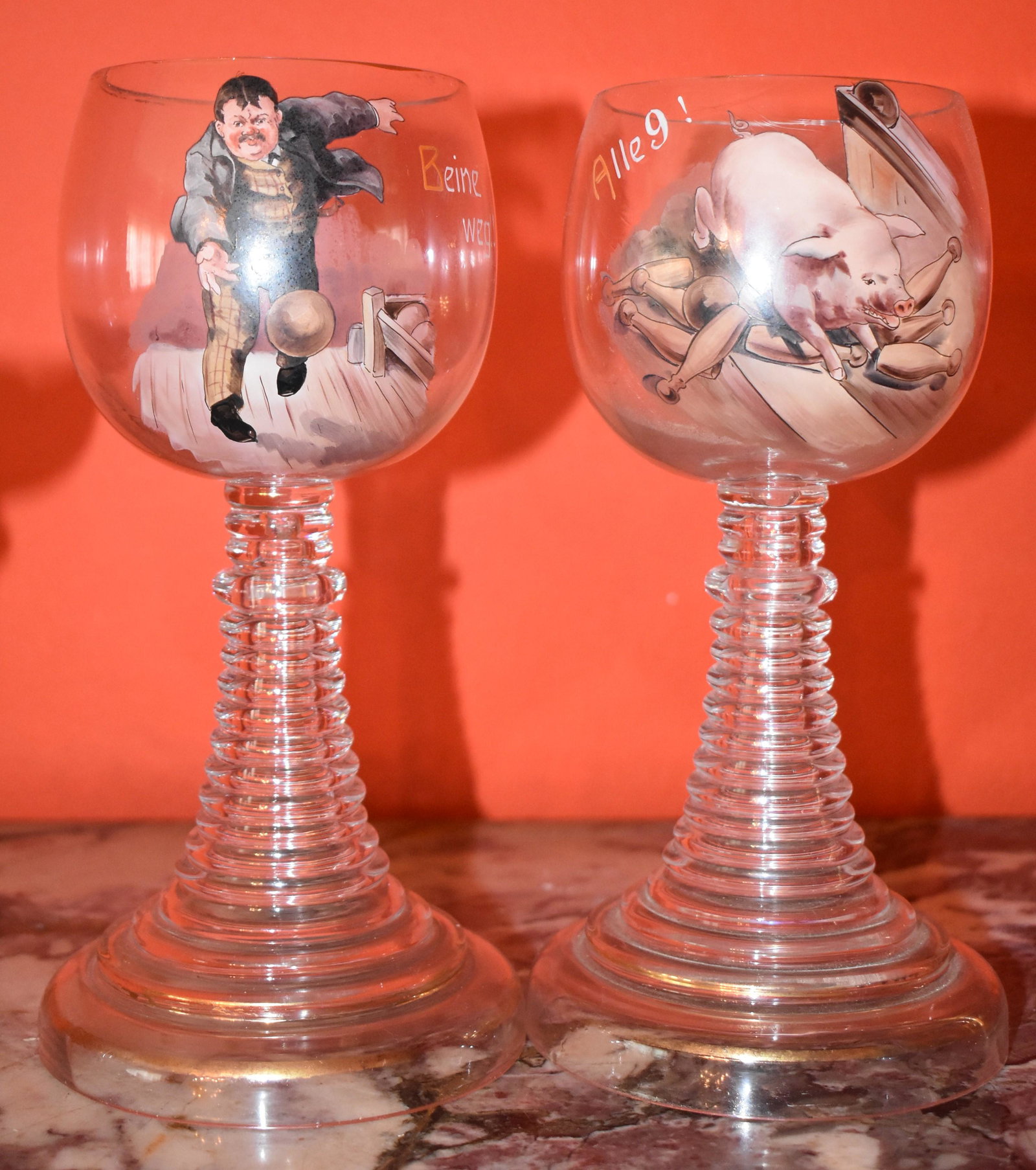 Fine Pair Of Late 19th C. German Glass Roemers: one with polychrome painted bowler, the other with pig knocking down pins both on stepped cylindrical bases. Height 9"