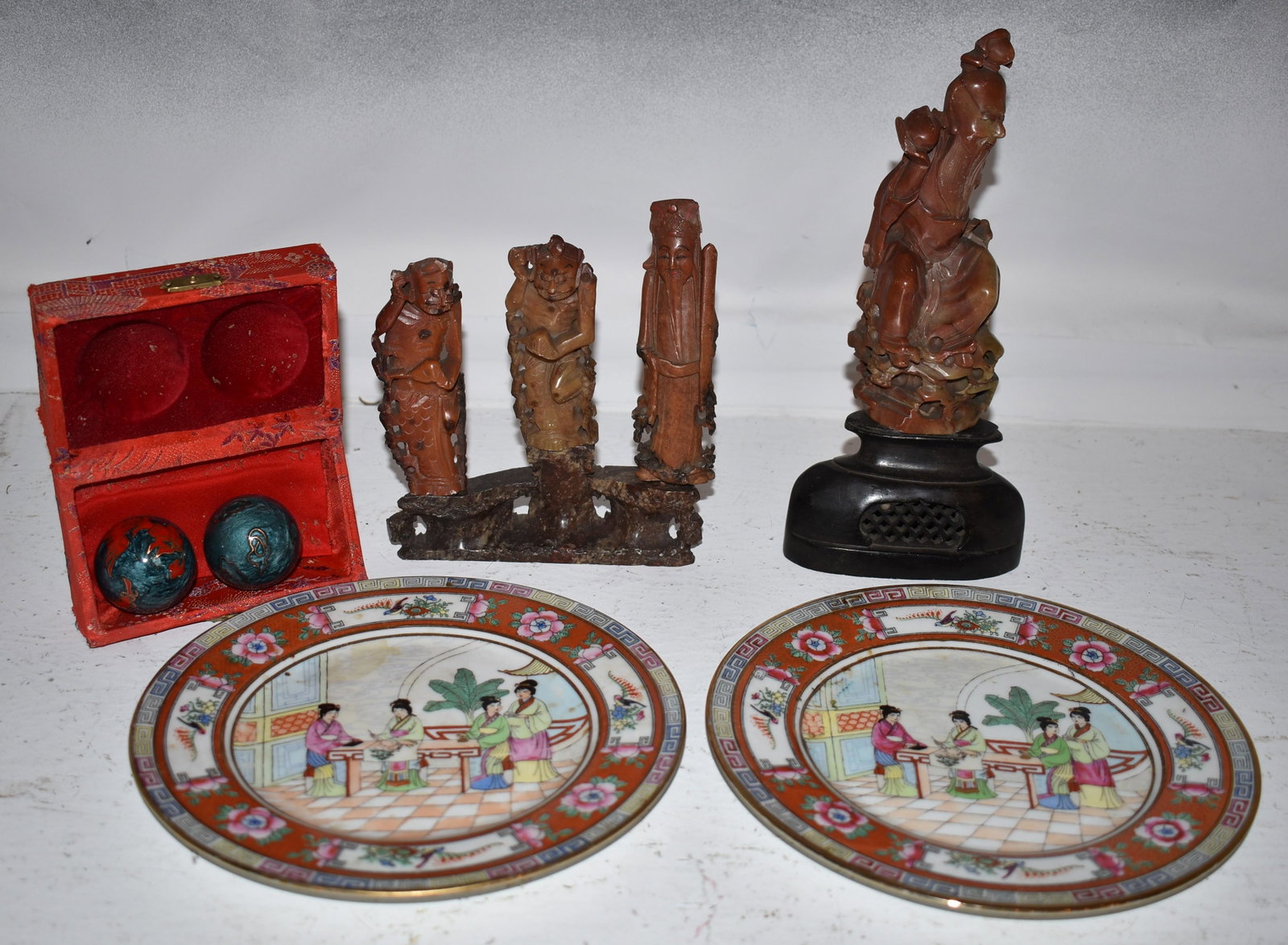 String of Carnelian Beads Chinese Soapstone Figures: along with four soapstone carved figures set onto two base, a pair of Rosemedallion style plates and apair of musical balls in original fabric covered box. Height of tallest figure 9 3/4"
