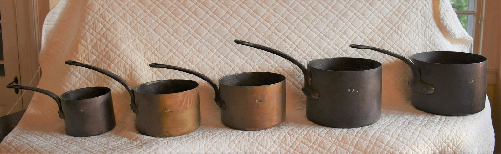 Graduated Set Of Five Antique French Cooking Pots: along with wrought iron hanger. The pots with iron handles all marked DG, the largest 10", 9 3/4", 8 1/2", 8", 6 1/4".Iron hanger Length 106"