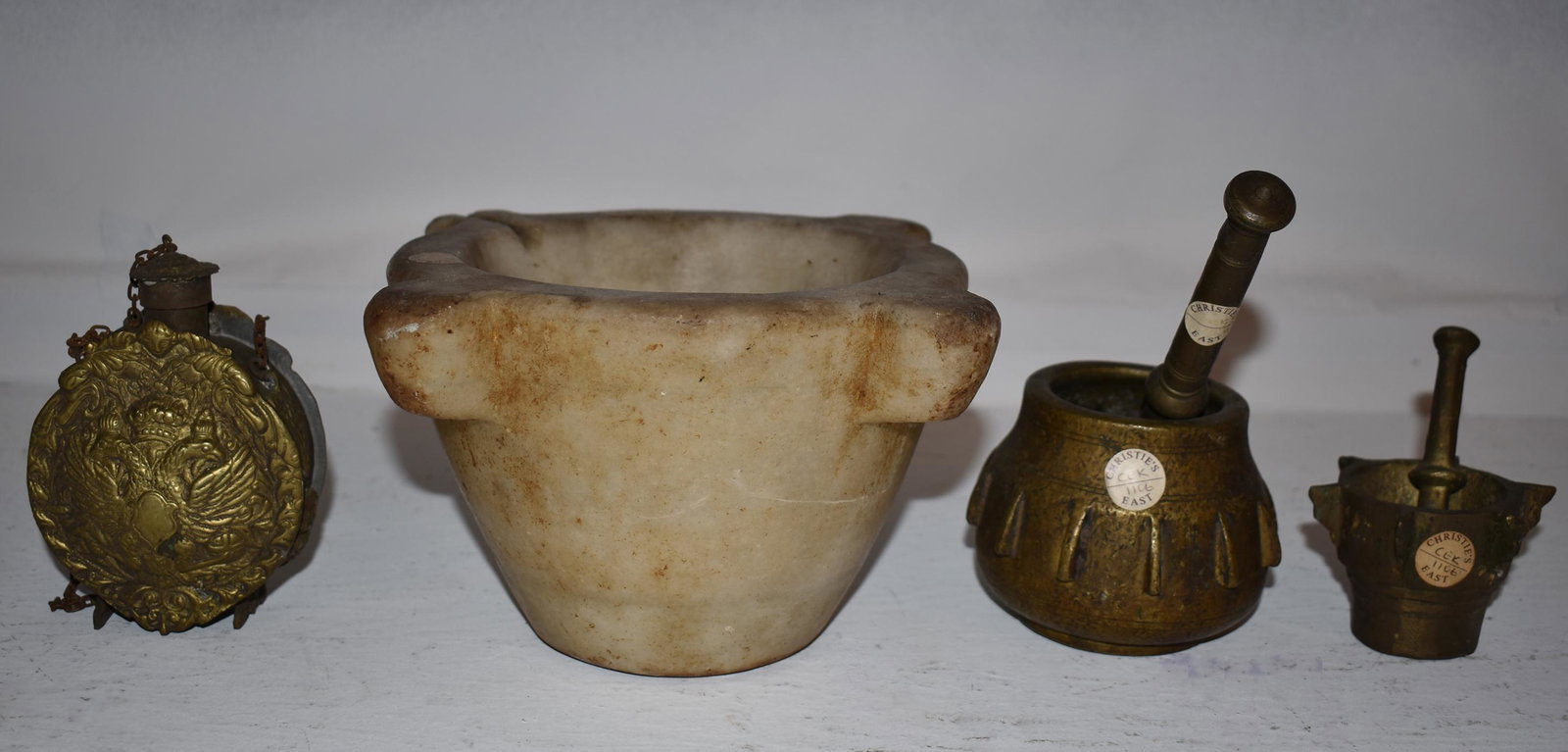 Collection Of Early Continental Mortars: the marble & one brass example with old Christies NY labels most likely 17th Century, the marble example possibly Italian, along with an early Continental brass repousse decorated flask . Marble morta