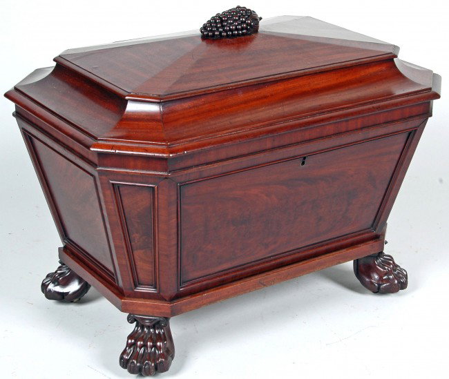 WILLIAM IV MAHOGANY CELLARETTE, ATT. JAMES SEDDON, : WILLIAM IV MAHOGANY CELLARETTE, ATT. JAMES SEDDON, LONDON, sarcophagus form, the hinged paneled lid with grape cluster finial, chamfered case, open interior on canted paw feet, recessed casters. H. 26