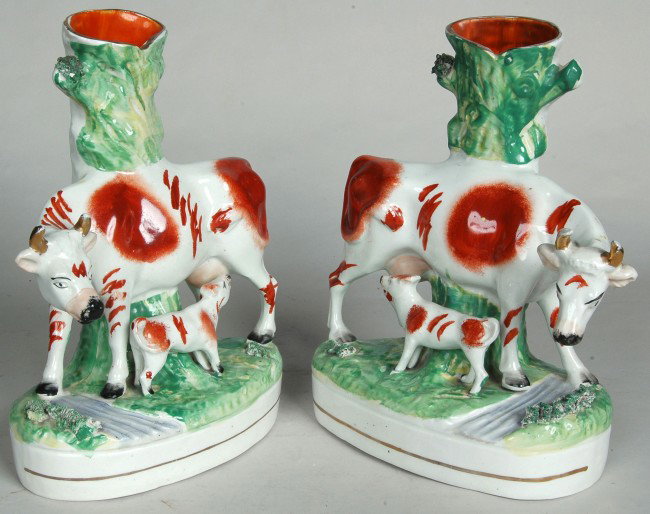 PAIR OF STAFFORDSHIRE SPILL VASES, 19TH C. depictin: PAIR OF STAFFORDSHIRE SPILL VASES, 19TH C. depicting nursing cows, rusticated green tree trunks with red and gilt decorated heifers nursing calves. H. 11 1/4"