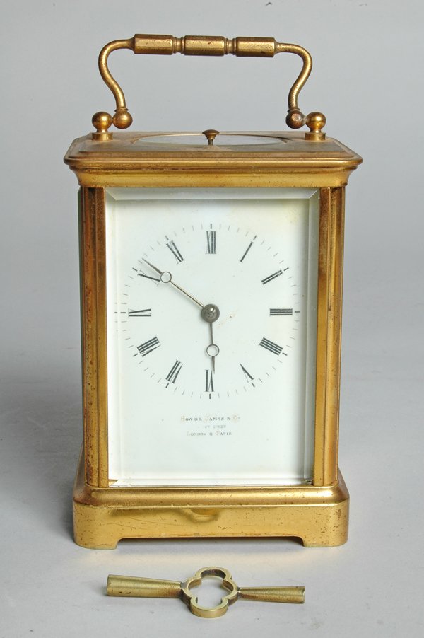 BRASS & GLASS REPEATER CARRIAGE CLOCK: the dial marked Howell James & Co London & Paris, complete with key. Ht. to handle 6 3/4". Provenance: Estate of Maryanne Klopman, Marblehead, Massachusetts. According to her son, Mrs. Klopman purchas