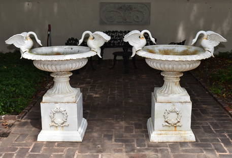 FINE PAIR OF CAST IRON SWAN HANDLE GARDEN URNS: ON PEDESTAL The reeded classical campagna form urns each with a pair of opposing swan handles with outspread wings. The urns set atop a fine pair of wreath decorated square pedestals with stepped