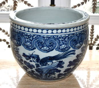 EARLY CHINESE UNDERGLAZE BLUE PORCELAIN FISH BOWL: Of cylindrical form with pierced carrying handles, the body with handpainted cobalt blue decoration featuring a Koi pond. Height 25" Diameter 12 1/2"