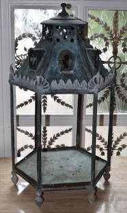 GOTHIC DESIGN ANTIQUE COPPER HEXAGONAL LANTERN: Having a ball spire above pierced architectural design top with six arched dormer windows and anthemion frieze above 6 framed panels, 1 hinged, reserved for glass (now absent) resting on ball feet.