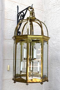 LARGE OCTAGONAL GILT BRASS HALL LANTERN: This large and ornate gilt brass hall lantern of octagonal form sturdy acanthus cast openwork hanger with sheet brass scroll top panels with turned brass pendants. Fitted with a two tiers of four