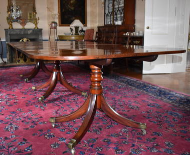 GEORGE III MAHOGANY TRIPLE PEDESTAL DINING TABLE: An exceptional George III mahogany triple pedestal dining table. The rectangular top having rounded corners, each top of three fine richly grained and colored mahogany boards tilting above three pedes