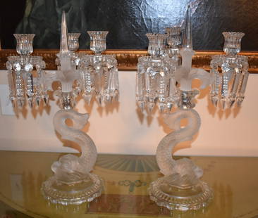 PAIR OF 19TH CENTURY BACCARAT CRYSTAL CANDELABRA: The candelabra with three cut crystal lights with faceted prism drops supported by dolphin standards on circular molded bases. Height 19" Width 10" Note: hairline crack to one dophin standard and chip