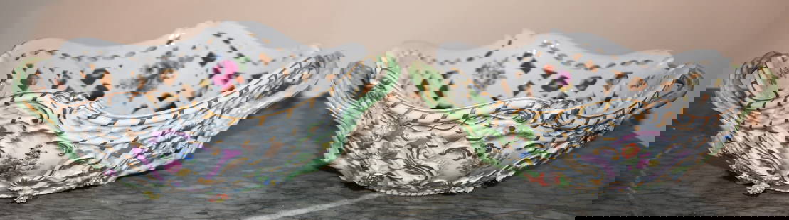 FINE PAIR OF MEISSEN RETICULATED FLORAL BASKETS: The baskets with light green openwork handles and scalloped reticulated boat formed bodies with applied polychrome floral sprigs and painted floral decoration. Height 3 1/2" Width 9 1/2" Both with res